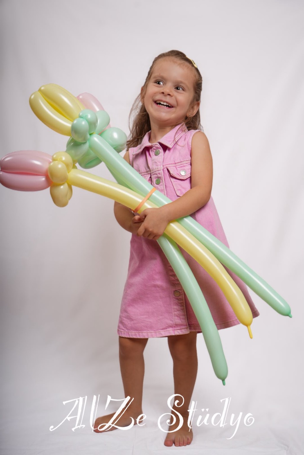 Renkli balon çiçekleriyle gülümseyen çocuk